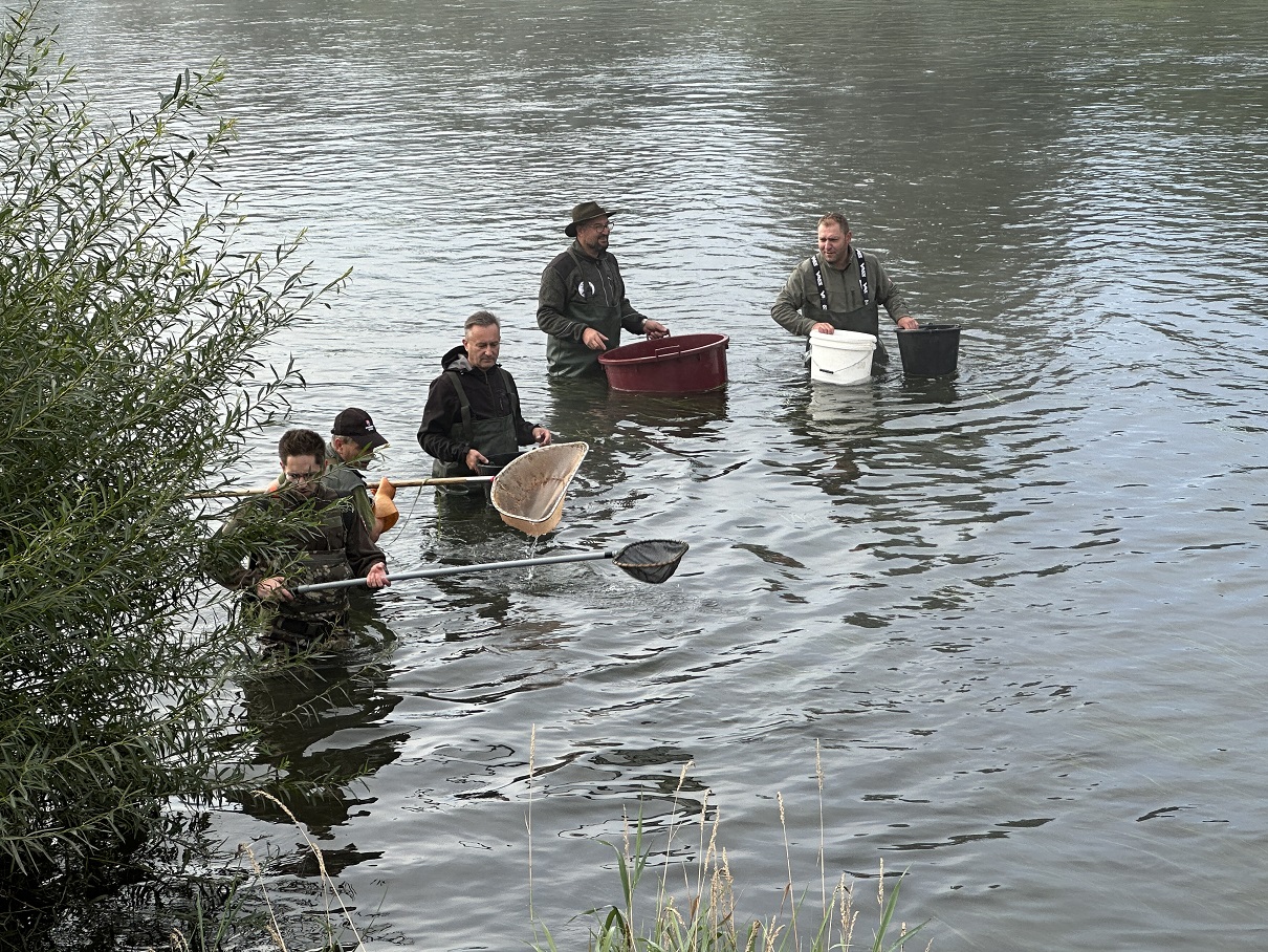 Ďalšia skupina z lovcom odlovuje ryby v brehovej časti.